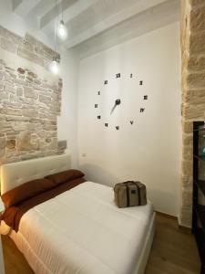 1 dormitorio con 1 cama y reloj en la pared en White Home, en Bisceglie