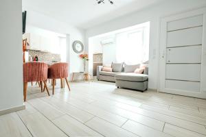 a white living room with a table and a couch at Design Suites Efharis (Sauvignon) in Nea Peramos