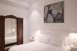 a bedroom with a white bed and a mirror at NUEVO Katu Kale Apartamentuak CENTRO HISTORICO in Getaria