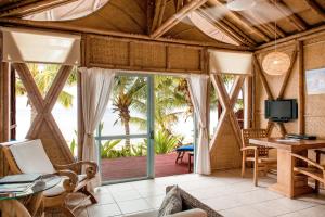 a living room with a view of the ocean at Magic Reef Bungalows in Rarotonga