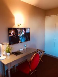 TV a/nebo společenská místnost v ubytování Hôtel Le Gue Du Holme