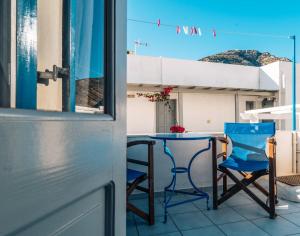 a blue chair and a table on a balcony at Meropi Rooms in Kamares