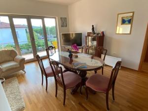 a dining room with a table and chairs and a television at Apartments Apolon Izola in Izola
