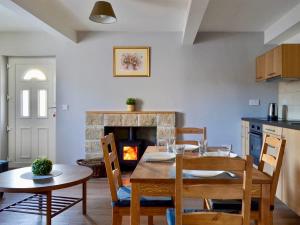 een eetkamer met een tafel en een open haard bij The Wee Coolins-holiday home with wood burner in Strathcarron