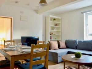 a living room with a blue couch and a table at The Wee Coolins-holiday home with wood burner in Strathcarron