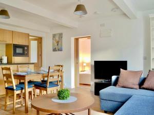 een woonkamer met een blauwe bank en een tafel bij The Wee Coolins-holiday home with wood burner in Strathcarron