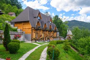 una grande casa in legno con tetto a gambero di Neva Apartments a Mokra Gora