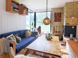 uma sala de estar com um sofá azul e uma mesa de madeira em Holiday home Jægerspris XVII em Jægerspris