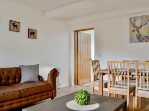 a living room with a couch and a table at The Coolins cottage with wood burner in Strathcarron