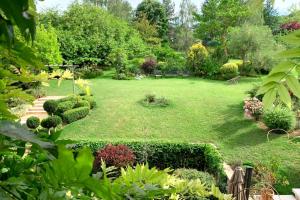 a garden with a large lawn with bushes and trees at Beautiful country house located 50min from Paris Eiffel Tour - Demeure d'exception à 50min de Paris Tour Eiffel in Hodent