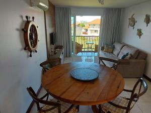 una mesa de madera y sillas en la sala de estar. en Flat Praia dos Carneiros en Praia dos Carneiros