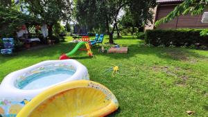 einen Hinterhof mit einem Pool mit Wasser und einem Spielset in der Unterkunft Agroturystyka u Pruszyńskich in Mońki