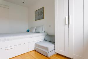 a small bedroom with a bed and a stool at PortoVivo Bonjardim Apartamento in Porto