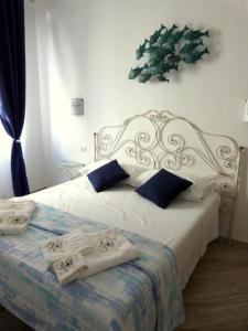 a bedroom with a white bed with towels on it at Clelia's Boutique Rooms & Suites in La Maddalena