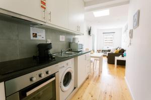 a kitchen with a sink and a washing machine at PortoVivo Bonjardim Apartamento in Porto