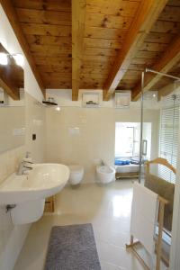La salle de bains est pourvue d'un lavabo et de 2 toilettes. dans l'établissement BELLA VITA!, à Bellagio