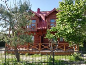 a log cabin with a fence in front of it at Domki całoroczne KATRINA in Krynica Morska