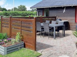 a wooden fence with a table and chairs on a patio at 6 person holiday home in Hemmet in Hemmet