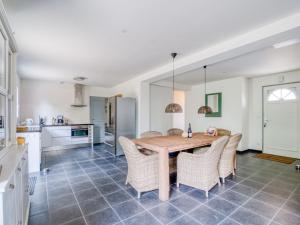 a kitchen and dining room with a wooden table and chairs at Quaint Villa in Aquitaine with Swimming Pool in Saint-Alvère