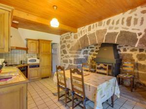 eine Küche mit einem Tisch und einem Steinofen in der Unterkunft Beautiful villa 150 m from the beach in Vic-sur-Cère