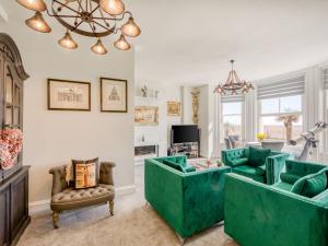 uma sala de estar com mobiliário verde e um lustre em Lovely Apartment Near Town Center em Folkestone