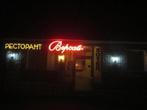 a neon sign for a petrol station at night at Versai Hotel in Svishtov