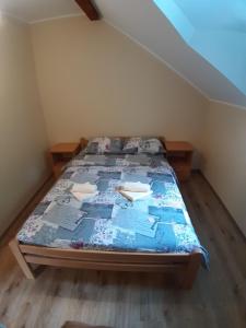a bedroom with a bed with a blue comforter at Vila Maljkovic Drina in Gvozdačko Polje