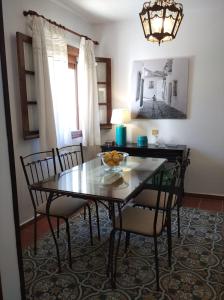comedor con mesa, sillas y lámpara de araña en Lovely Town House Casa La Senda, en Grazalema
