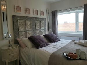 1 dormitorio con 1 cama con ventana y plato de comida en Abbey Field - Cyanacottages en Whitby