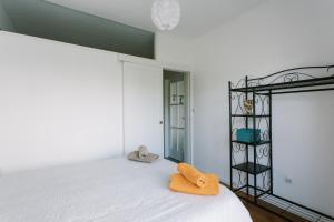 ポルトにあるPortoVivo Quental Apartamentoのベッドルーム1室(オレンジ色の枕が付いたベッド1台付)