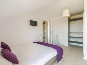 a white bed with purple pillows in a bedroom at Villa Cicha in Karwia