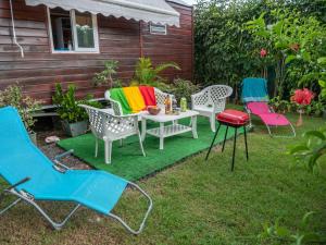 eine Gruppe Stühle und ein Tisch auf einem Rasen in der Unterkunft La Roulotte De Tina in Le Moule