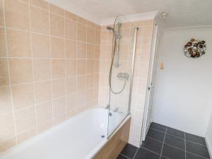 a bathroom with a shower and a bath tub at Abbey Vista in Whitby +11 photos