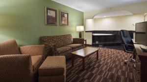 uma sala de estar com um sofá e um piano em Best Western Of Walterboro em Walterboro