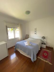 Habitación blanca con cama y ventana en Pousada La Sierra, en Campos do Jordão