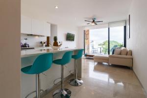cocina y sala de estar con encimera azul en Xaha Condo, en Playa del Carmen