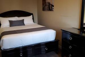 a bedroom with a bed with a black dresser at 2-Bedroom Apartment Sweet #2 by Amazing Property Rentals in Gatineau