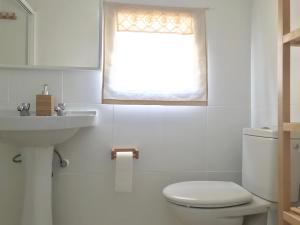 a bathroom with a toilet and a sink and a window at Casa ALBAYZÍN in Salobreña