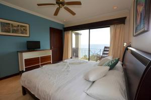 a bedroom with a bed with a large window at Fifth-Floor Condo with Breathtaking Ocean Views, Stylish Interior & Prime Location Near Flamingo Beach in Playa Flamingo +23 photos