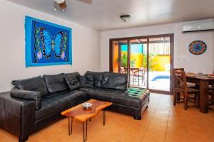 sala de estar con sofá de cuero negro y mesa en Nicely Priced Duplex in Surfside with Private Pool and AC in Every Room, en Potrero