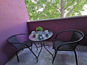 - Balcón con mesa pequeña y 2 sillas en Cozy Corner Apartments - Free parking & Wi-fi, en Ćuprija