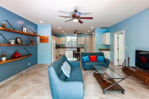 un soggiorno con pareti blu e ventilatore a soffitto di Nicely Decorated Ground-Floor Unit in Front of Pool at Pacifico in Coco a Coco