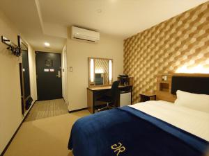 Habitación de hotel con cama y escritorio en Green Rich Hotel Yonago Ekimae (Artificial hot spring Futamata Yunohana) en Yonago