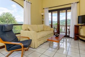 ein Wohnzimmer mit einem Sofa und einem Tisch in der Unterkunft Birds-Eye Ocean View in Nicely Priced Top-Floor Unit in Flamingo in Playa Flamingo
