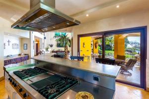 a kitchen with a stove top oven in a room at Spectacular Mediterranean-Style Mansion with Beachfront Views in Playa Flamingo in Playa Flamingo