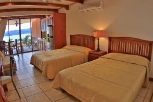 twee bedden in een kamer met uitzicht op de oceaan bij Hotel room-style ocean-view unit in Flamingo with pool in Playa Flamingo