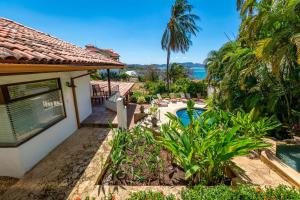 a house with a swimming pool and palm trees at Luxury Flamingo home with ocean view sleeps 10 - walking distance from beach in Playa Flamingo