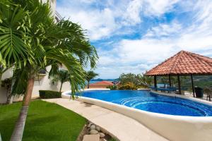 a swimming pool in a yard with a gazebo at Prestine ocean view 3BR condo in Playa Hermosa