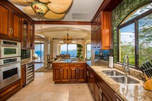 a kitchen with wooden cabinets and a view of the ocean at Prestine ocean view 3BR condo in Playa Hermosa