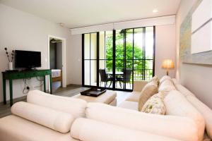 sala de estar con sofá blanco y TV en Minimalist, Modern Design on 2nd Floor in Coco with Garden-View Balcony, en Coco